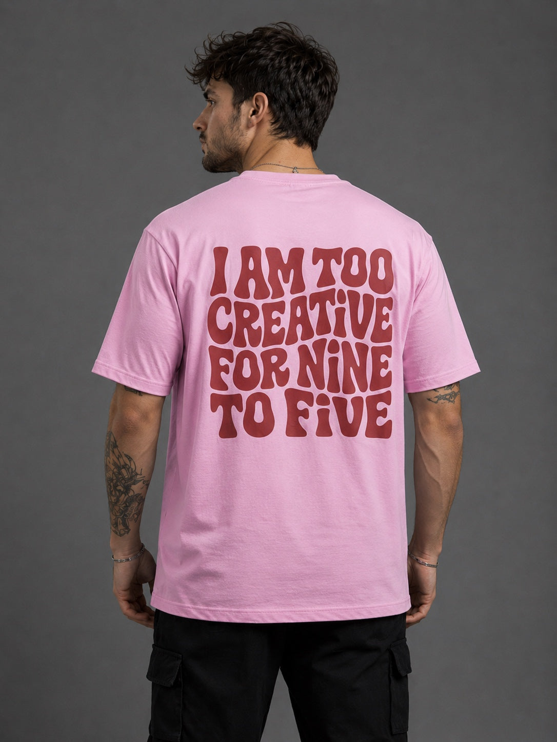 Man wearing baby pink oversized graphic t-shirt back view