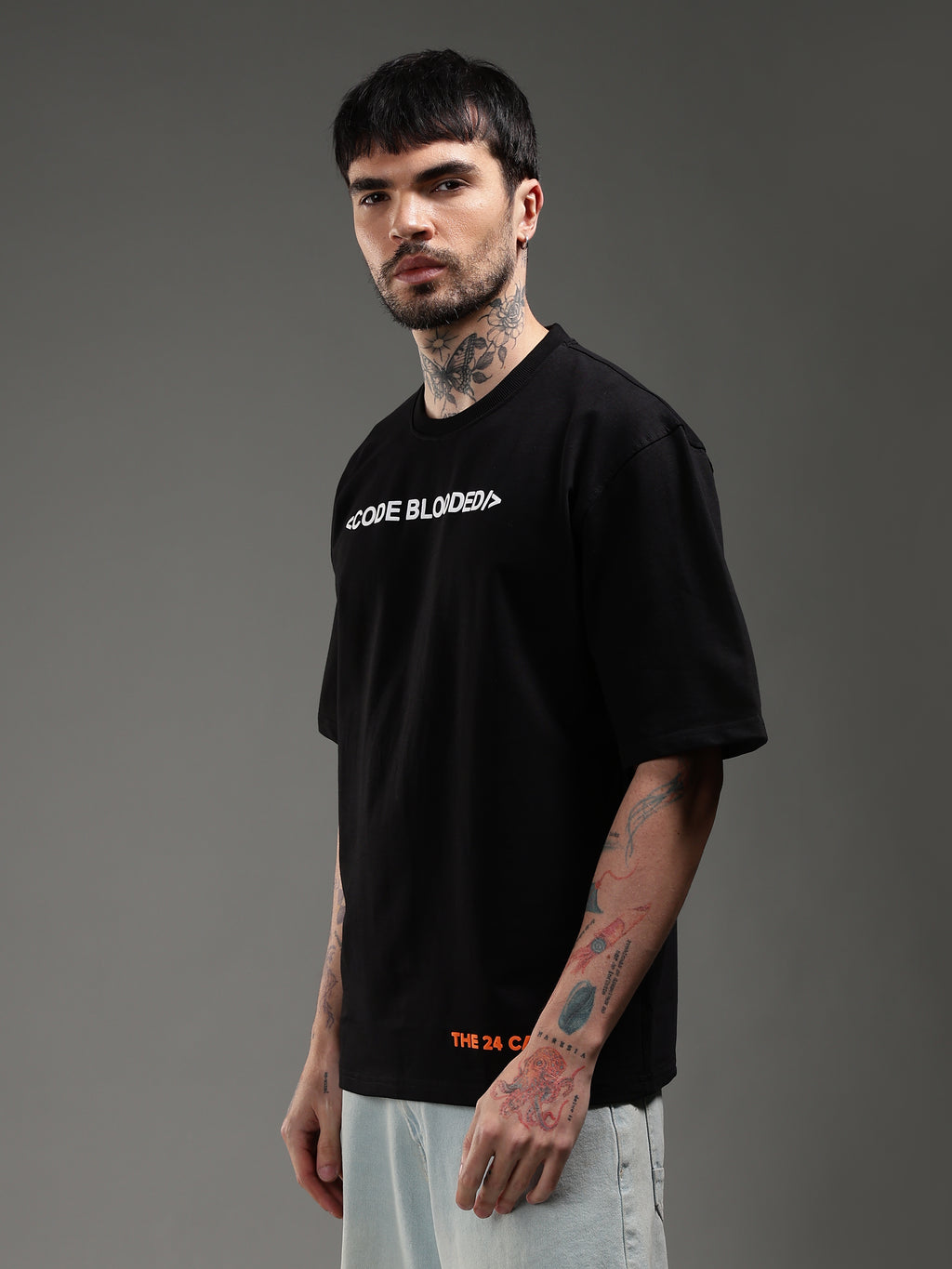 Model wearing black Code Blooded oversized t-shirt side view streetwear