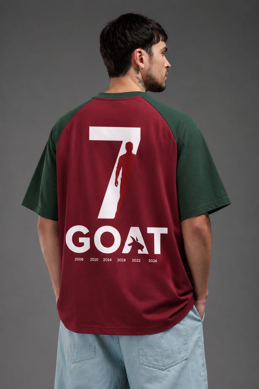 Man wearing CR7 GOAT oversized maroon and green football t-shirt back view