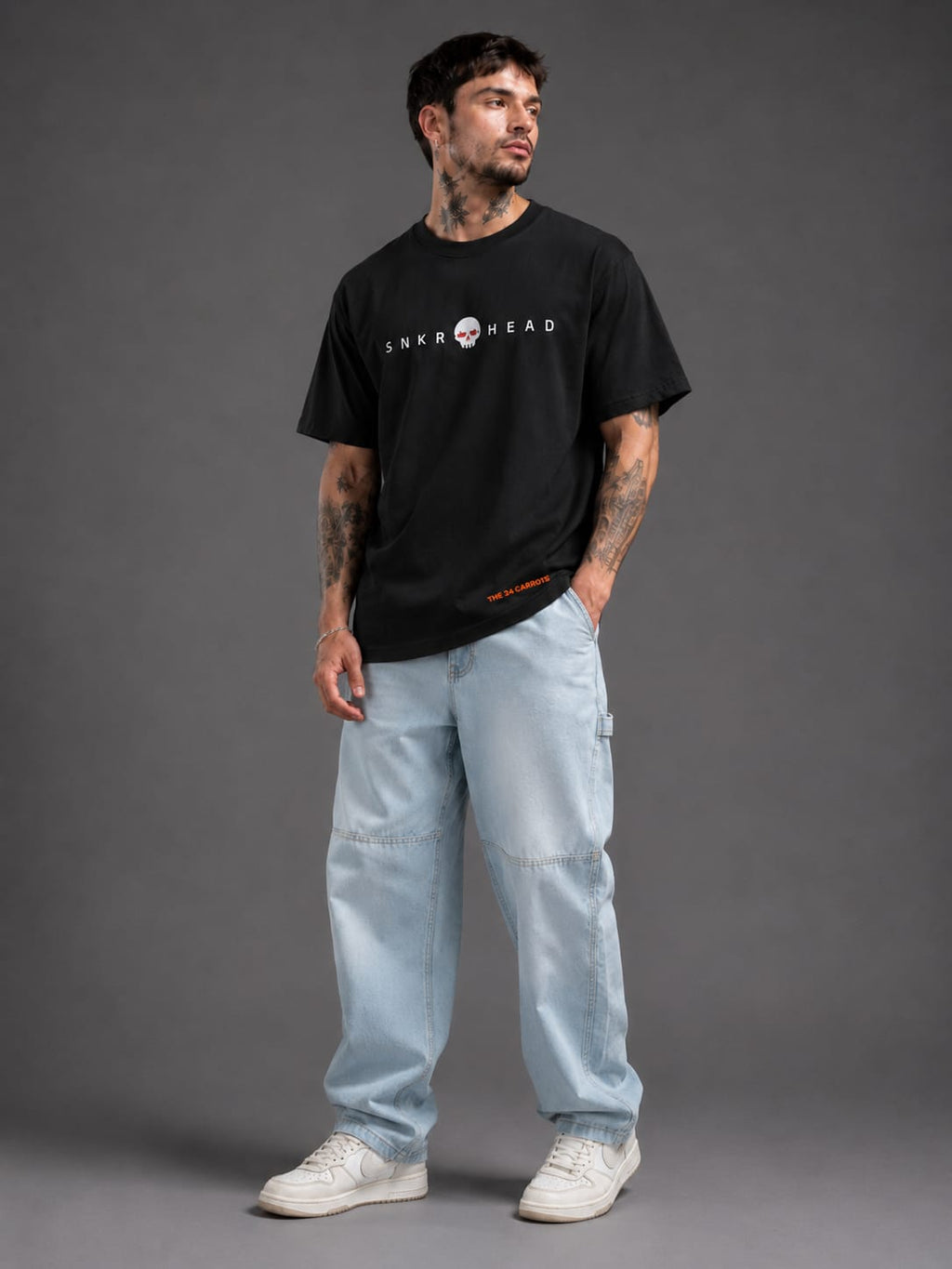 Male model wearing SNKR HEAD oversized off black streetwear t-shirt by The 24 Carrots.