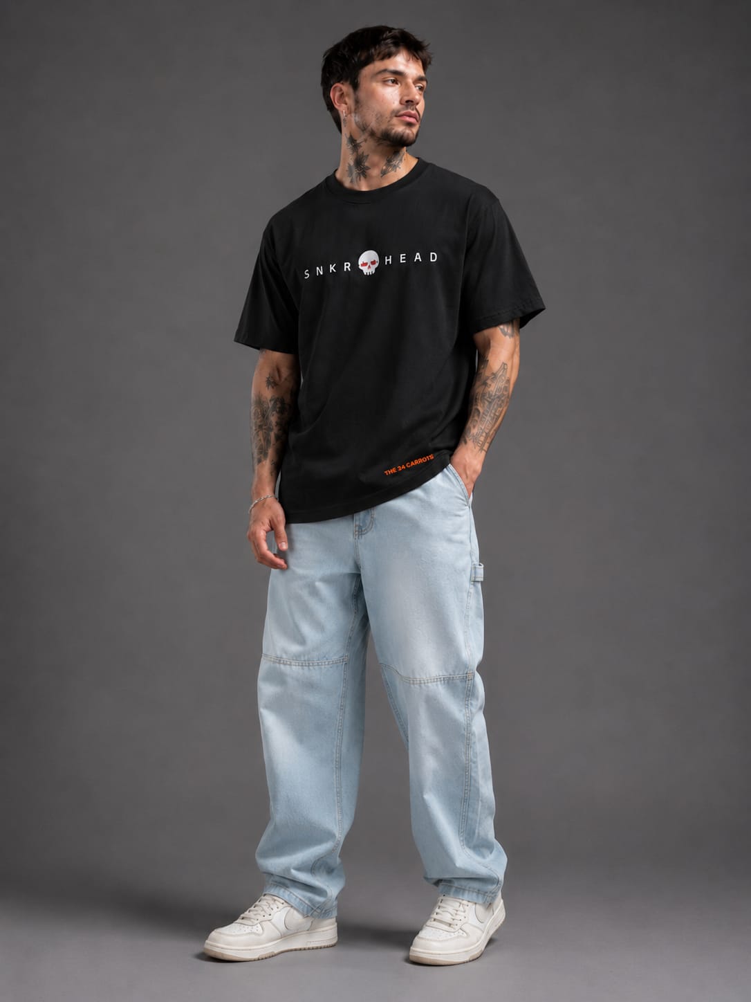 Male model wearing SNKR HEAD oversized off black streetwear t-shirt by The 24 Carrots.